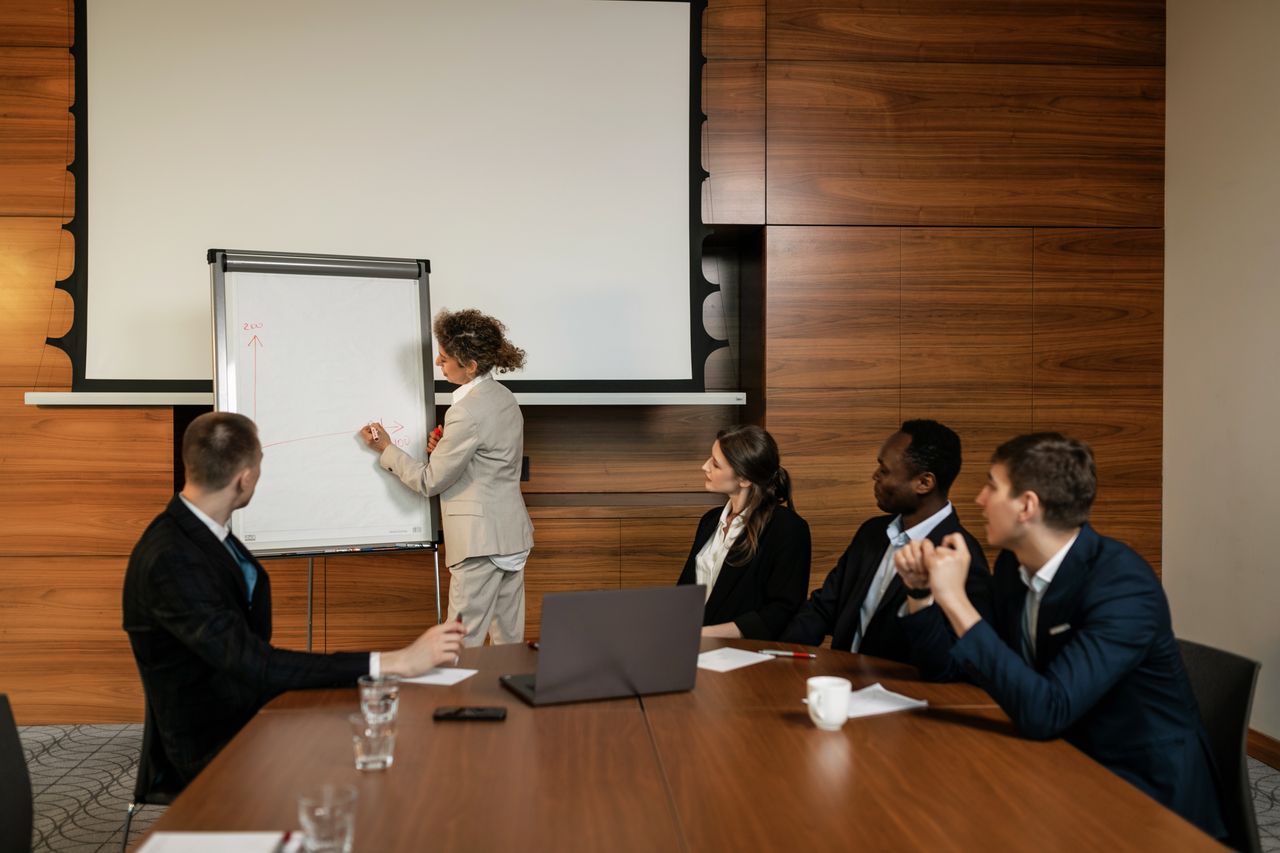 about-us A professional team engaged in a conference room meeting with a presentation.