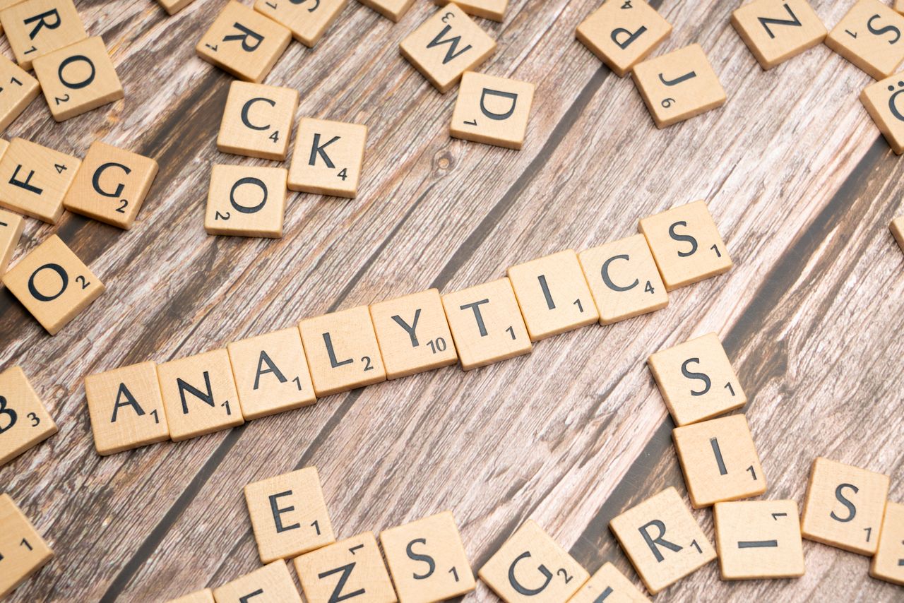 about-us-01 Scrabble tiles spelling 'Analytics' on a wooden surface, symbolizing data analytics concept.